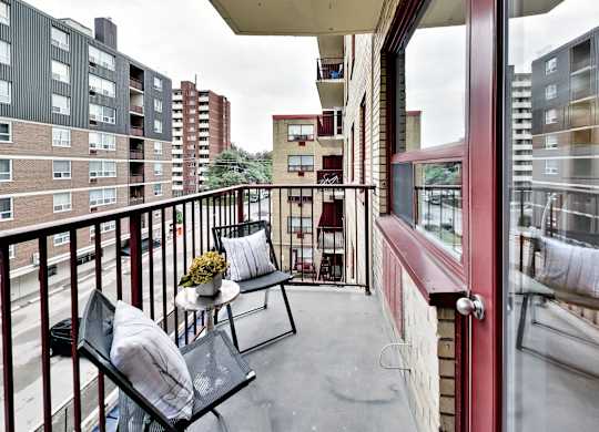 a small balcony with two chairs and a table on it