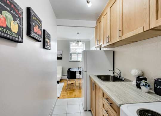 a kitchen with wooden cabinets and a sink and a refrigerator
