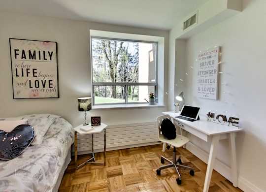 a bedroom with a desk and a bed and a window