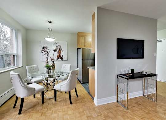 a living room and dining room with a glass table and chairs