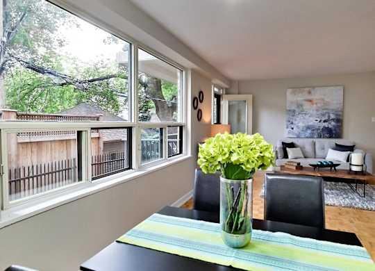 a dining room with a table and a vase of flowers