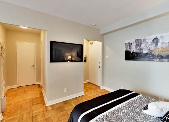 a bedroom with a tv on the wall and a bed