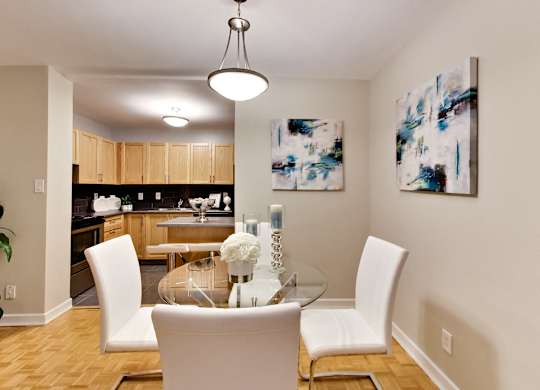 a dining room with white chairs and a glass table