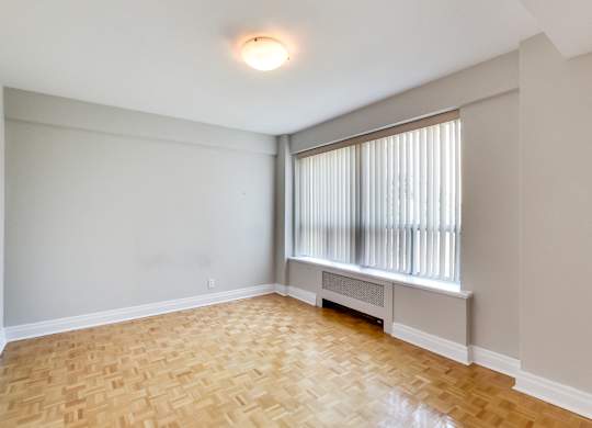 an empty living room with wood flooring and a large window