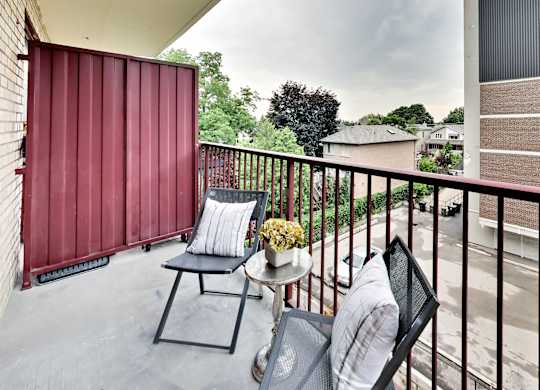 a balcony with two chairs and a table