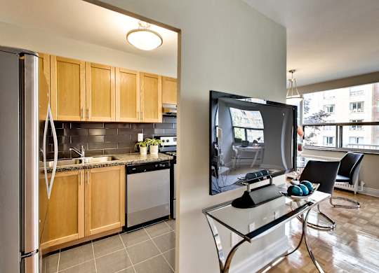 a kitchen and dining room with a flatscreen tv on the wall