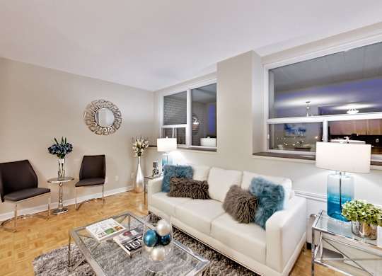 a living room with a white couch and a glass coffee table