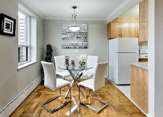 a dining room with a glass table and white chairs