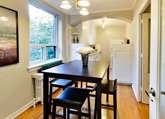 a dining room with a black table and four black stools