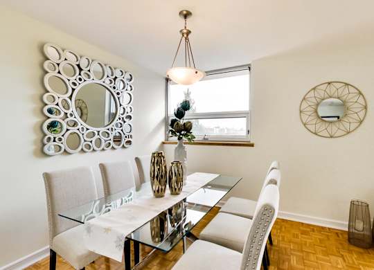 A dining room with a glass table and chairs.