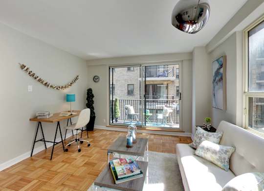 a living room with a couch and a desk and a large window