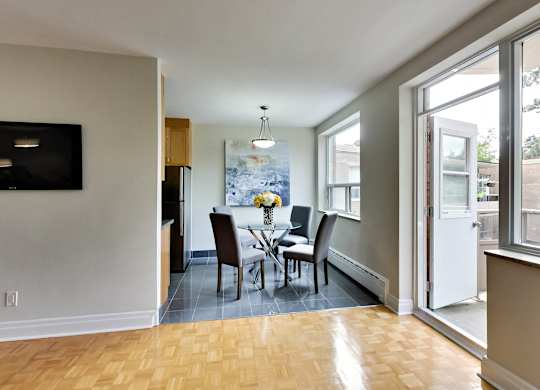 a dining room with a table and chairs and a large window