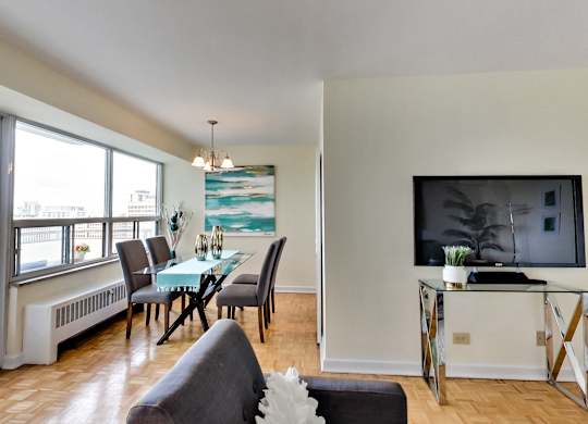A living room with a grey couch and a glass table.