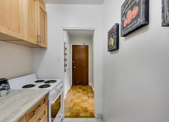 a kitchen with a stove and a door to a hallway