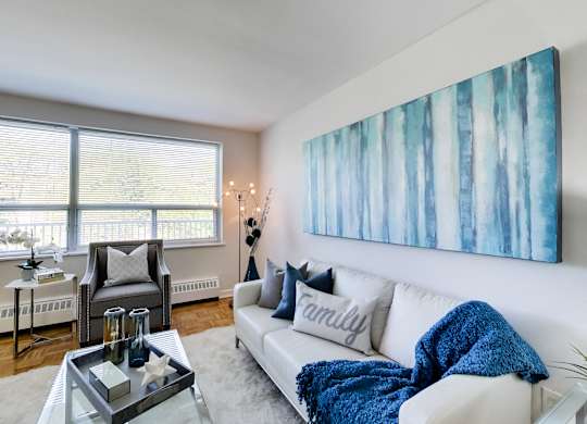 a living room with a white couch and a blue blanket