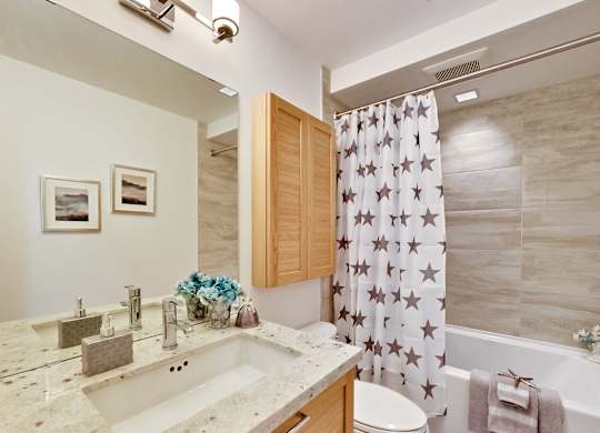 a bathroom with a shower curtain and a sink and a toilet