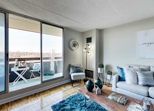 a living room with large windows and a couch and a rug