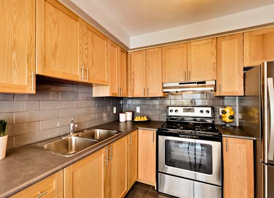 a modern kitchen with wooden cabinets and stainless steel appliances