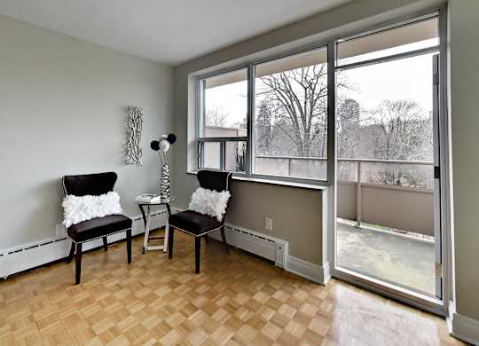 a living room with two chairs and a large window