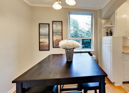 a dining room with a table and chairs and a window