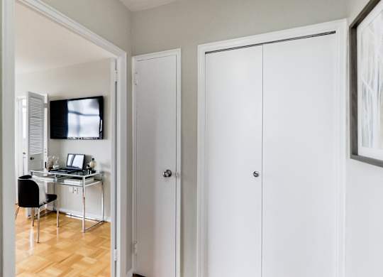 A white door is open to a room with a desk and a chair.