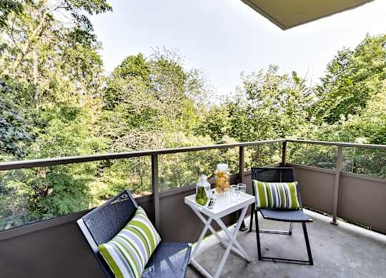 a patio with two chairs and a table on a balcony