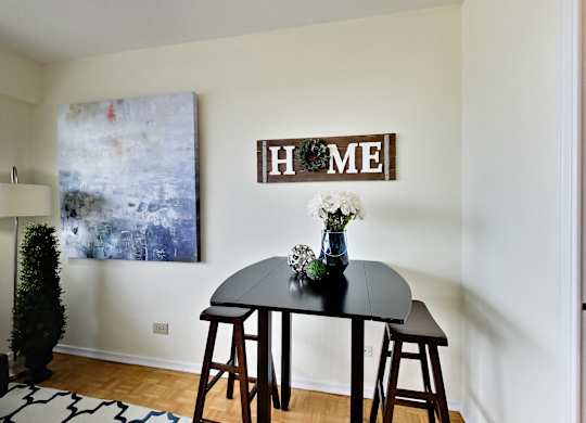 A black table with a vase of flowers on it and a sign that says