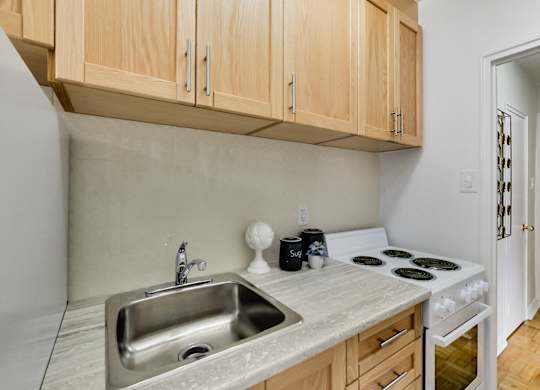 a kitchen with a sink and stove and wooden cabinets