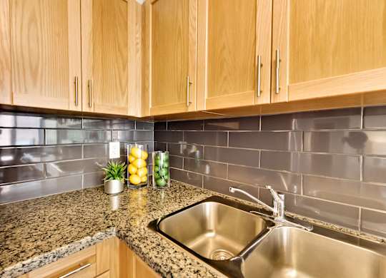 the kitchen has a stainless steel sink and granite counter tops