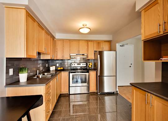 a large kitchen with wooden cabinets and stainless steel appliances
