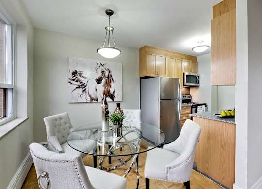 a kitchen and dining room with a glass table and chairs