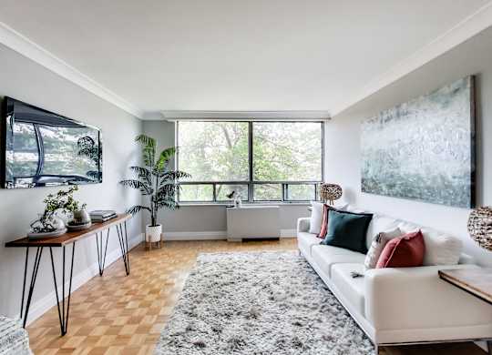 A living room with a white couch and a large window.
