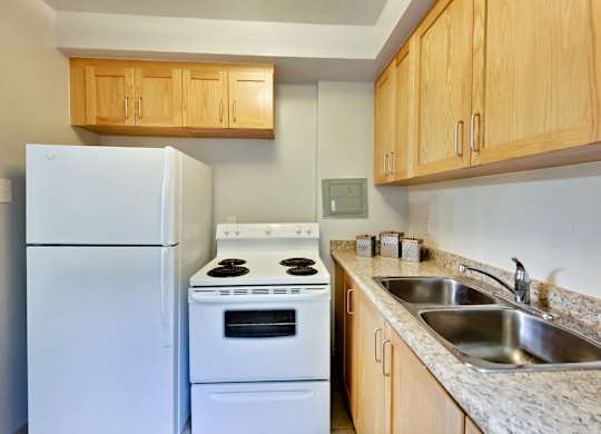 a kitchen with white appliances and granite counter tops and wooden cabinets