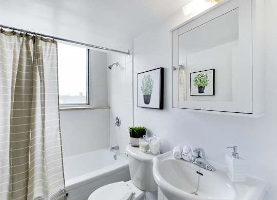 A white bathroom with a tub, toilet, and sink.