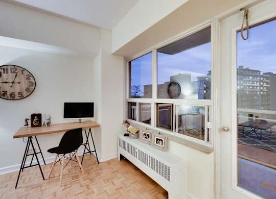 A room with a desk and a chair in front of a window.