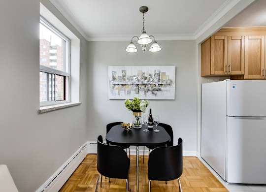 a dining room with a table and chairs and a refrigerator