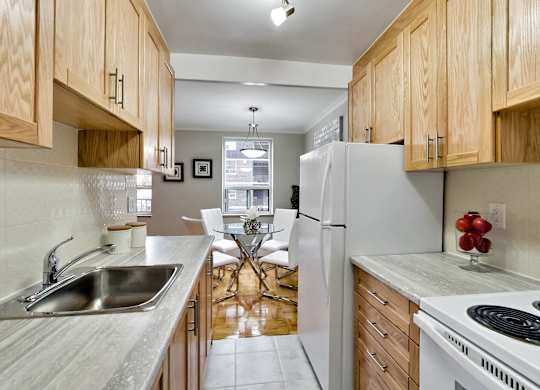 a kitchen with wooden cabinets and a sink and a refrigerator