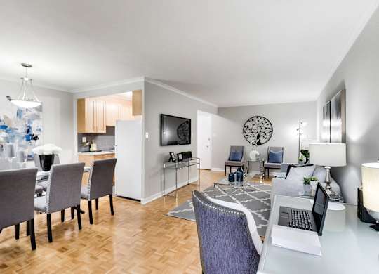 a living room and dining room with a table with a laptop on it