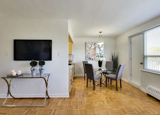 a living room and dining room with a table and chairs and a television