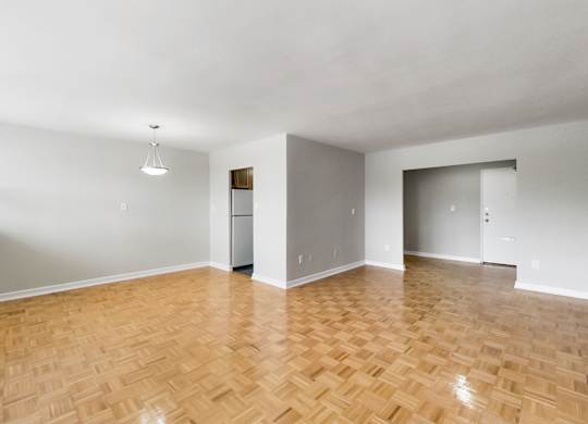 an empty living room with wood flooring and white walls
