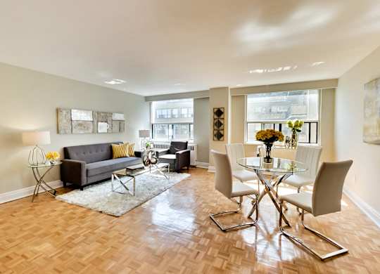 a living room and dining room with a glass table and chairs
