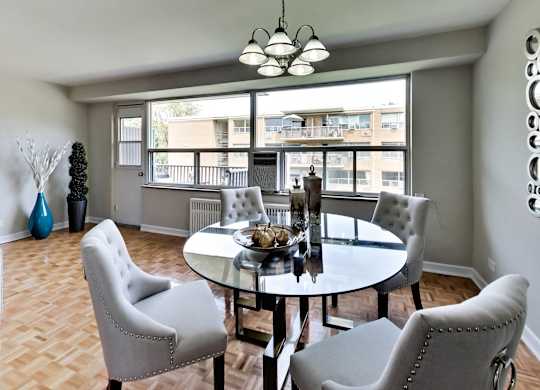 a dining room with a table and chairs and a large window