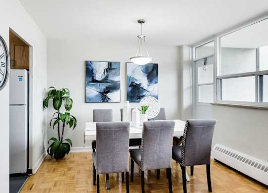 a dining room with a table and chairs and a large window