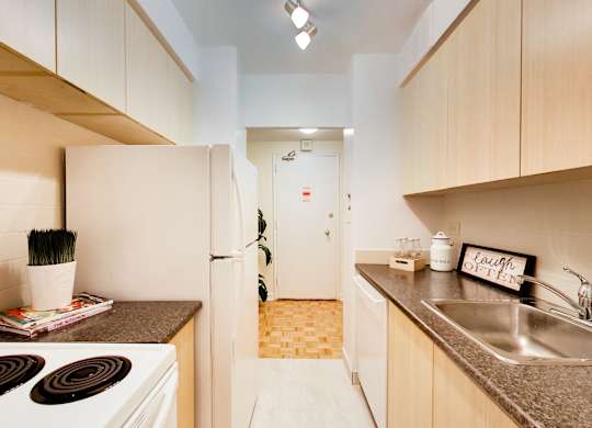 A kitchen with a white stove top oven and a white refrigerator.