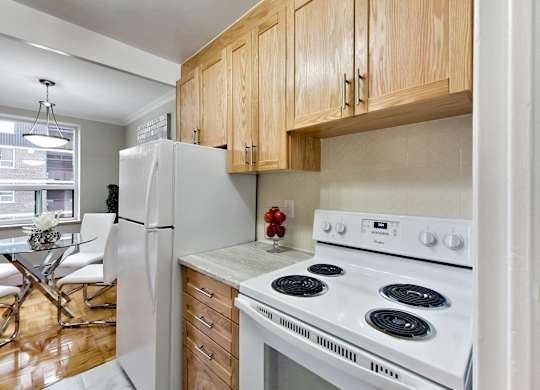 a kitchen with a white stove and refrigerator and wooden cabinets