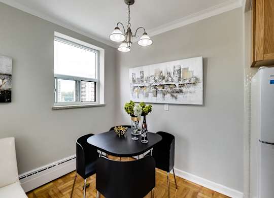 a dining room with a black table and chairs