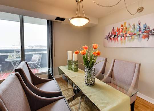a dining room with a glass table and chairs and a large window