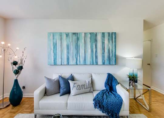 a living room with a couch and a painting on the wall