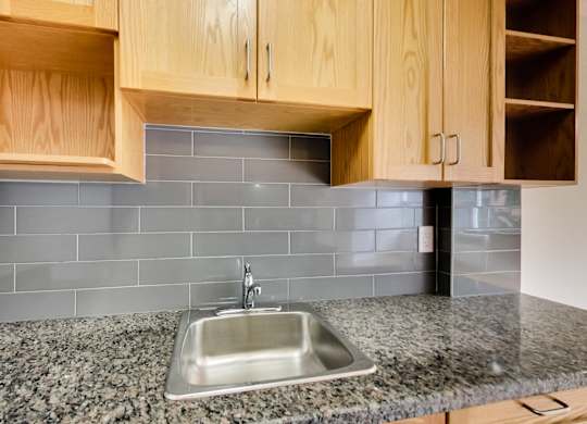 a stainless steel sink in a kitchen with granite counter tops