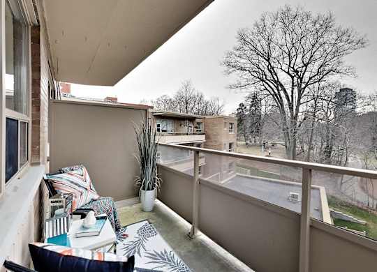 a balcony with a couch and a view of a pool and a tree